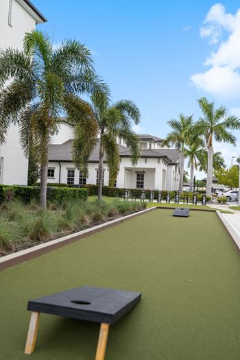 A golf course with palm trees and a building in the background